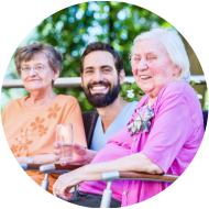 Nurse drinking coffee with seniors on terrace