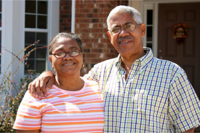 Senior Minority Couple Standing Outside Their Home